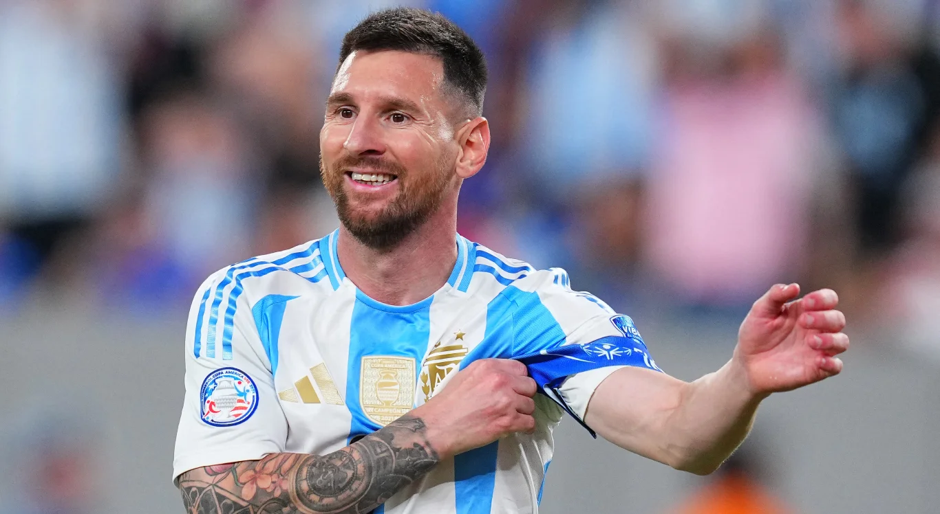 Imagem de Messi ajeitando a faixa de capitão da Argentina e sorrindo