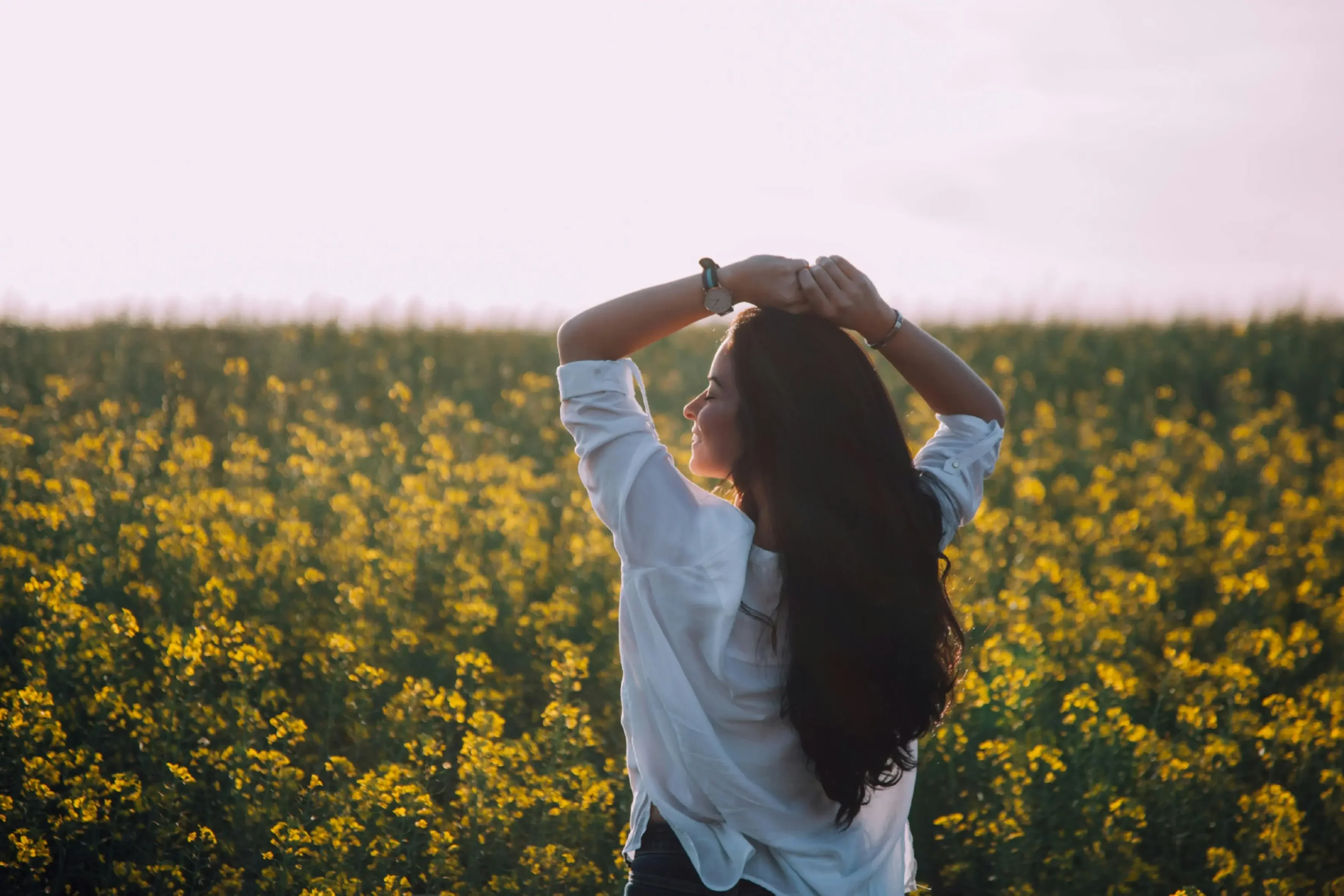 Imagem ilustrativa de uma mulher feliz em um campo florido