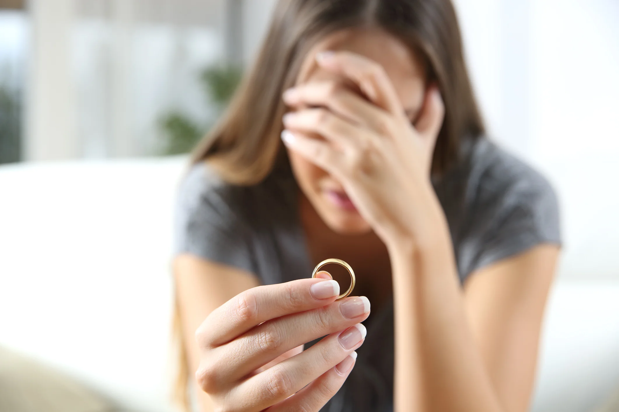 Mulher decepcionada devolvendo a aliança de casamento.