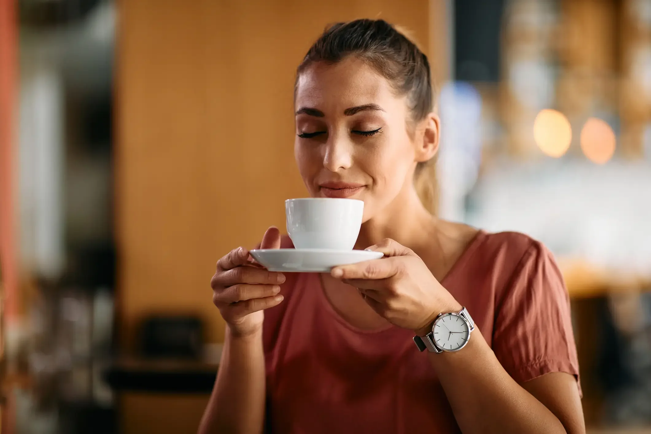 Imagem ilustrativa de mulher segurando uma xícara, sentindo o aroma do café