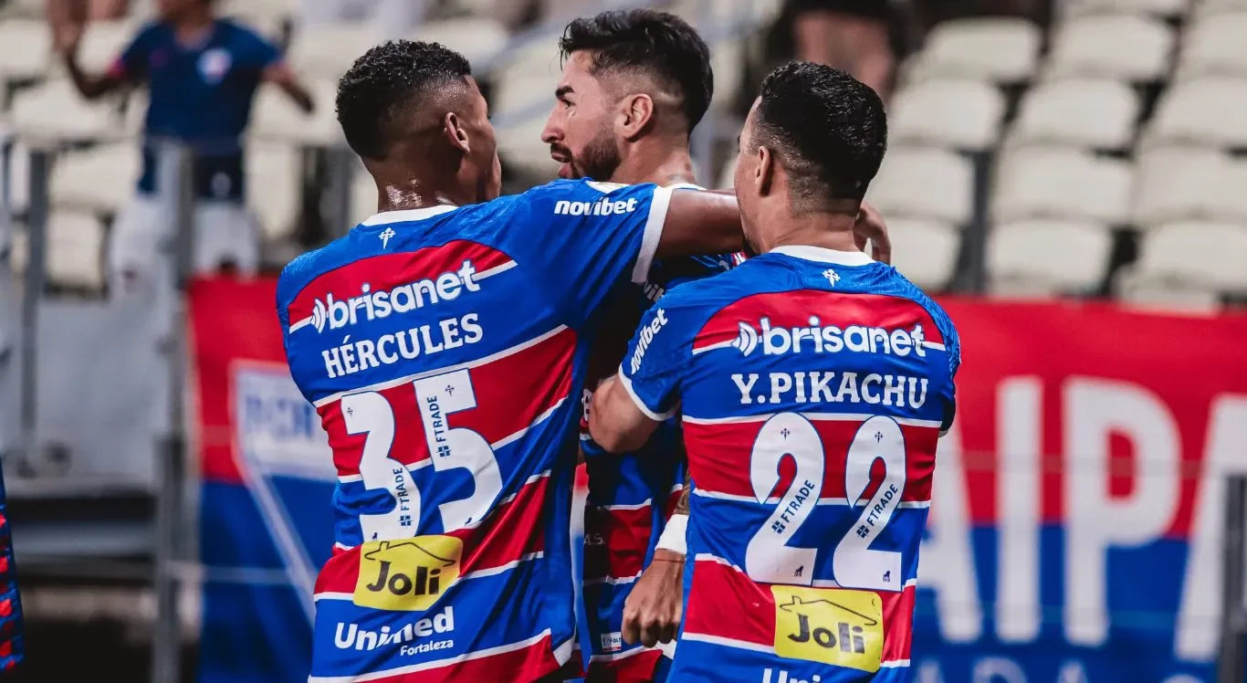 Imagem de três jogadores do Fortaleza abraçados