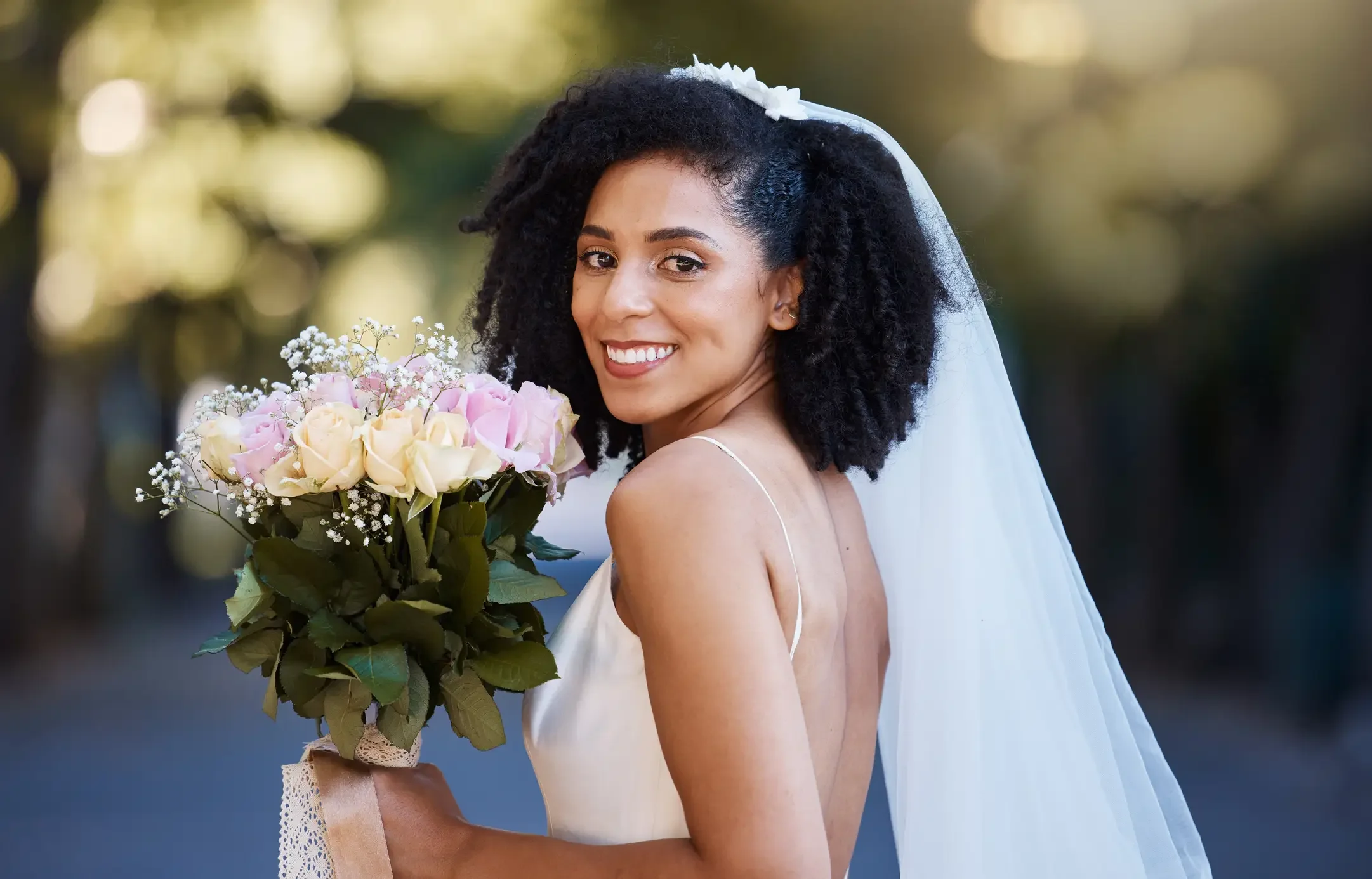 Imagem ilustrativa de noiva de cabelos cacheados sorrindo