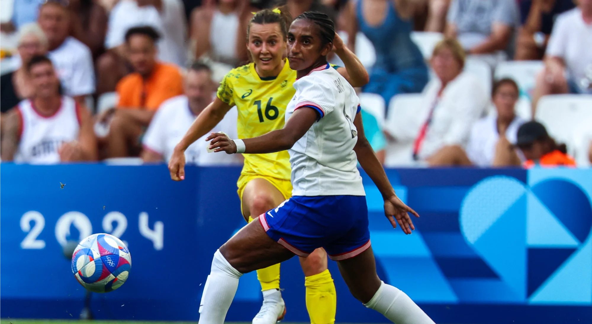 A atacante australiana Hayley Raso e a defensora americana Naomi Girma disputam bola em duelo entre Austrália e EUA dos Jogos Olímpicos de Paris 2024