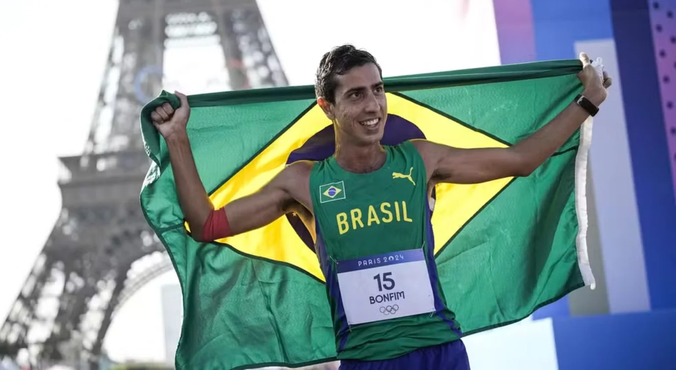 Imagem de Caio Bonfim com a bandeira do Brasil