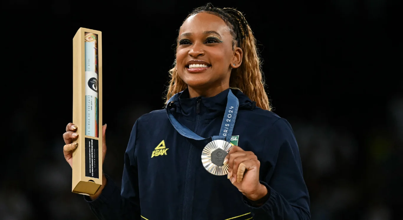 Imagem da ginasta Rebeca Andrade com a medalha de prata no p&oacute;dio dos Jogos de Paris 2024