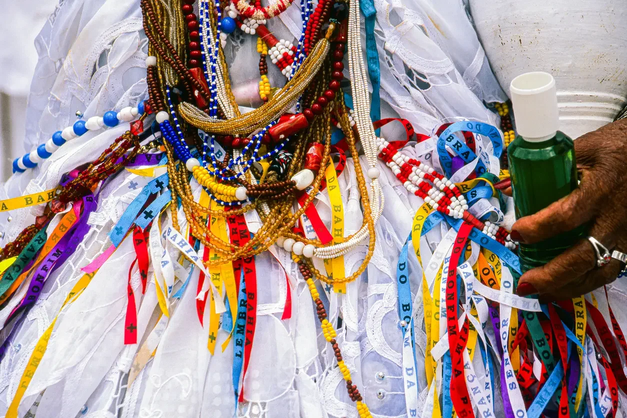 Imagem de mulher com itens de religião de matriz africana 