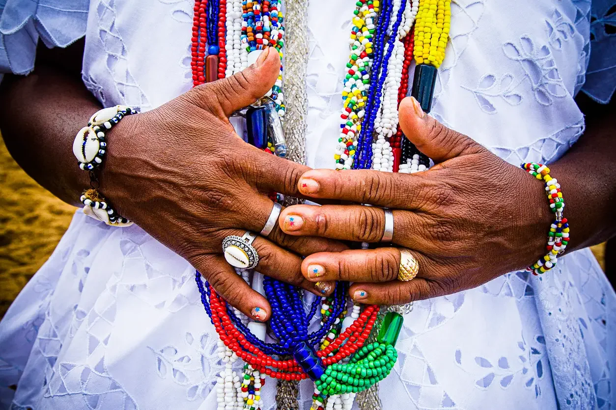 Imagem de mulher com itens de religião de matriz africana 