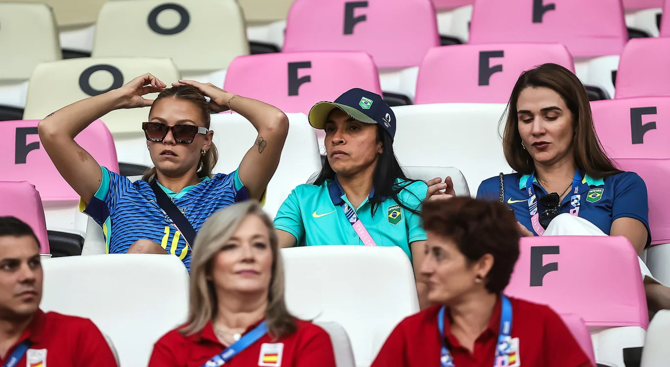 Imagem de Marta, suspensa, assistindo o Brasil enfrentar a Espanha pelas Olimpíadas de Paris