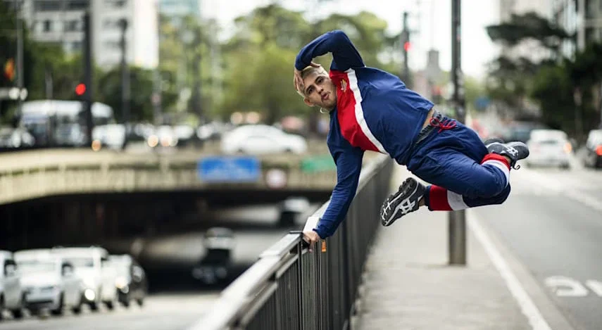 B-boy brasileiro Leony Pinheiro fazendo movimento de breaking em corrimão