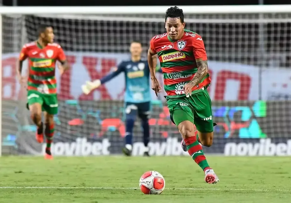 Imagem ilustra jogador da Portuguesa correndo com a bola