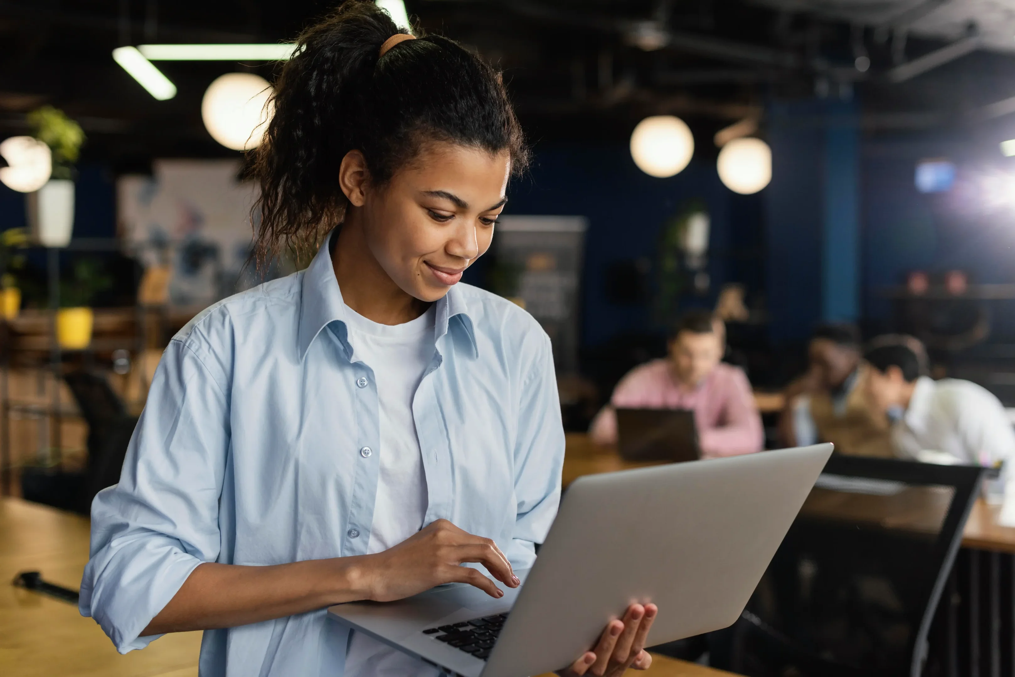 Imagem: mulher trabalhando com notebook em escritório.