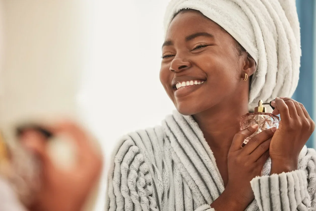 Imagem de uma jovem mulher parecendo alegre enquanto usa perfume