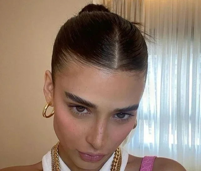 Livia Nunes, influenciadora digital, usando o "slick bun", o penteado oficial da tendência clean girl.