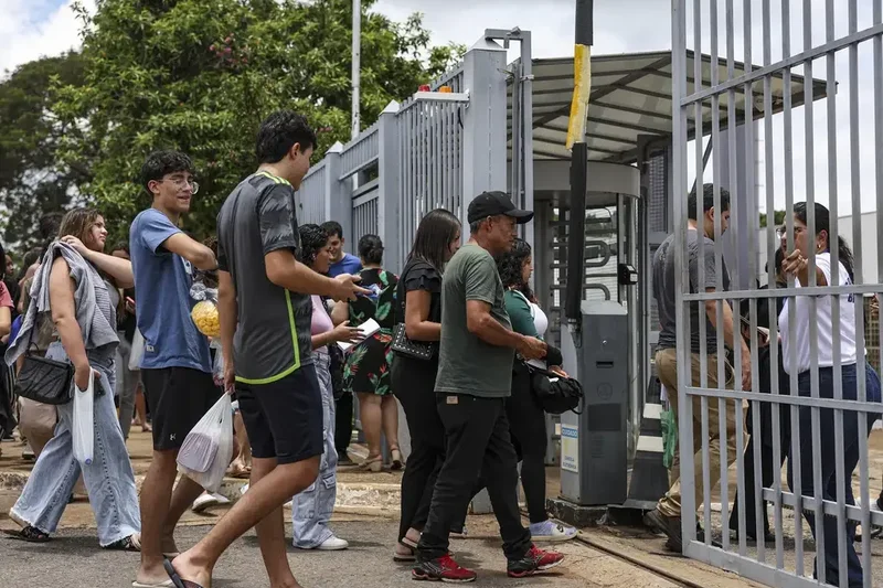 Imagem de estudantes chegando em local de prova para realizar o Enem, considerado a principal porta de entrada para o ensino superior.