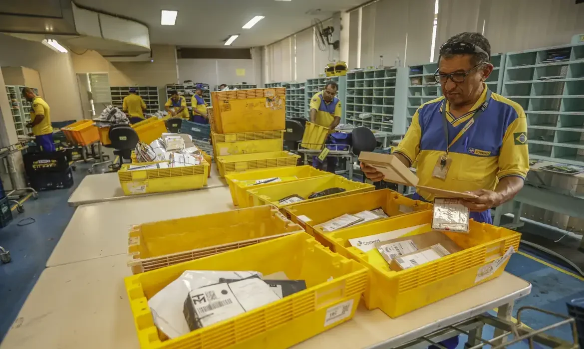 Imagem de carteiros trabalhando em agência dos Correios